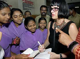 U.S. playwright Eve Ensler (right) signs autographs in Bombay