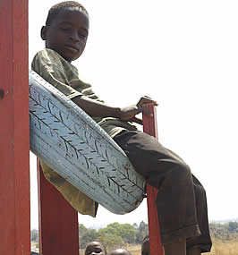 Tired and hungry, one of the children who has come for an interview with Caroline Lapham takes time to relax on the old car tyre 