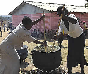 Members from the church cook lunch for the children using one of the three pots donated by well wishers