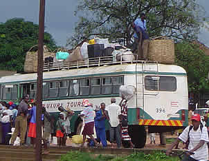 A bus fully loaded with goods picks up more people at Hauna Growth Point. 