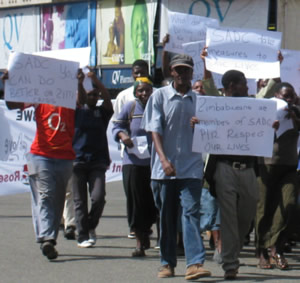 Approximately 50 men and women, many with babies on their backs, head towards the Zambian Embassy to deliver their petition for SADC action